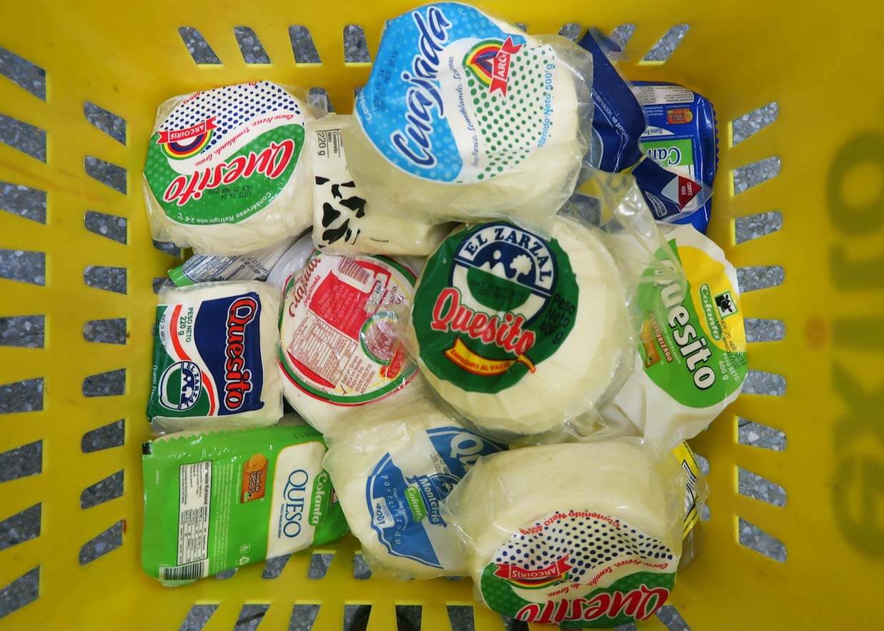 Cesta de supermercado llena de quesos colombianos