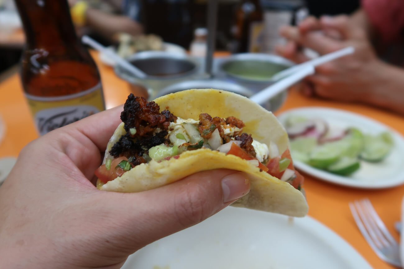 First person of eating a taco, one of the pros of traveling to Playa del Carmen