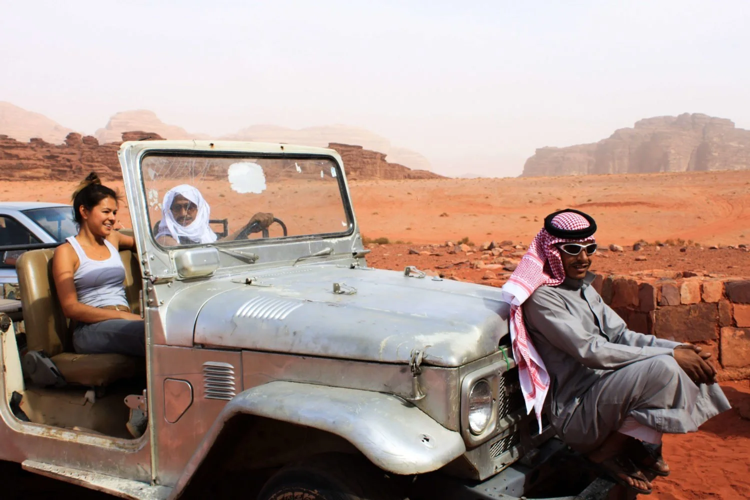 best travel tips and tricks cover image of Kim in jeep with locals in Jordan