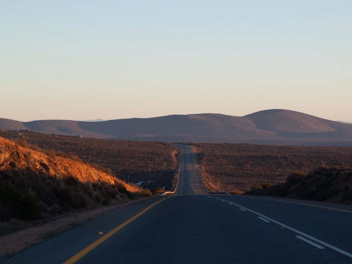 South Africa Road trip tips cover of sunrise view of highway driving towards the Namibian border.